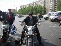 Папа Сан прикольно смотрится в пальто и галстуке и кепке на мотоцикле